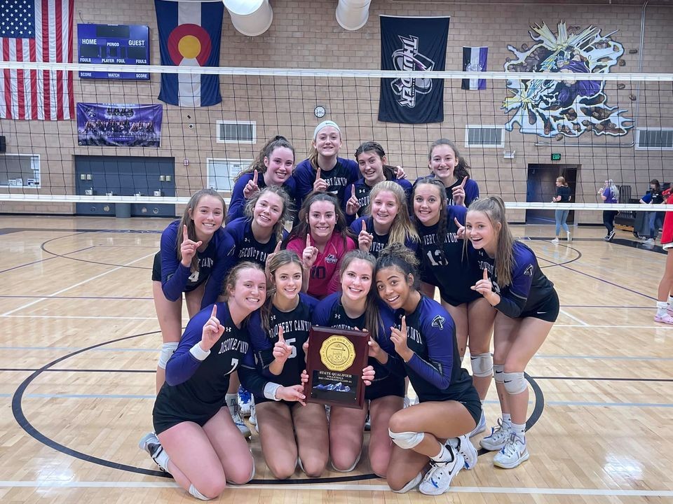 The DCCHS Girls Volleyball team on the volleyball court with their 2021 Regional Championship award.